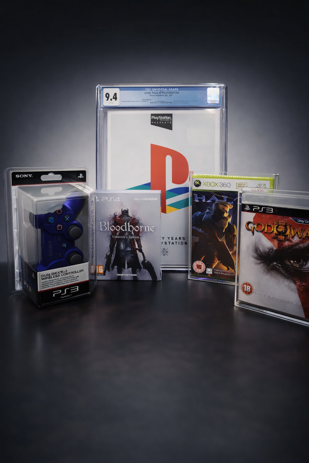 Collection of sealed video games including a PS3 controller and a graded magazine on a dark background.